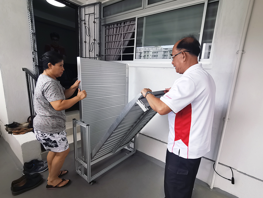 SGO Staff and Mr Lim’s FDW, Alma, unfolding the enhanced ramp applied under EASE, which is suitable for flats with multi-step entrances.
